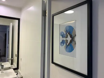 a bathroom with a mirror and a picture on the wall at Osma by Wynwood House in Lima