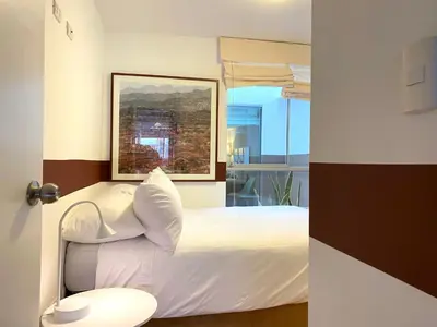 a bedroom with a white bed and a window at Nomad By Wynwood House in Lima
