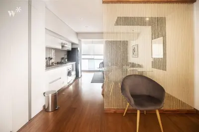 a living room with a chair and a kitchen at Las Mimosas by Wynwood House in Lima