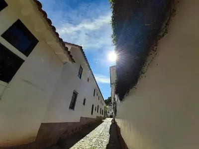 an alley with the sun shining between two buildings at Casa Mirador Cristo Blanco, Great view of Cusco in Cusco