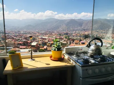 a kitchen with a stove and a view of a city at Sunny Apartment in Cusco