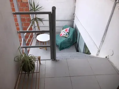 a stairway with a green pillow and a chair at Sunny Apartment in Cusco