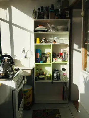 a kitchen with an open pantry filled with food at Sunny Apartment in Cusco