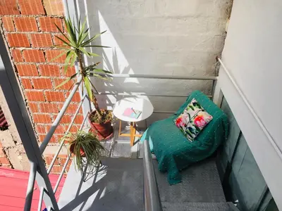 a stairway with a green couch and a plant at Sunny Apartment in Cusco
