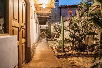 an alleyway in a house with a door and plants at MAMA GREEN HOSTAL - Eco Andean Experience and Permaculture Farm - Vegetarian Breakfast in Urubamba