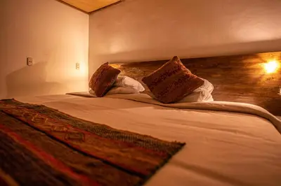 a bedroom with a bed with two pillows on it at MAMA GREEN HOSTAL - Eco Andean Experience and Permaculture Farm - Vegetarian Breakfast in Urubamba