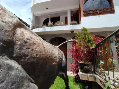 a statue of a bull in front of a building at Casa del Escultor in Cusco