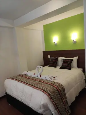 a bedroom with a large bed with towels on it at Casa del Escultor in Cusco