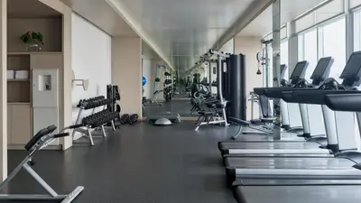 a gym with treadmills and chairs in a room at SOUMA Hotel, Vignette Collection by IHG in Lima