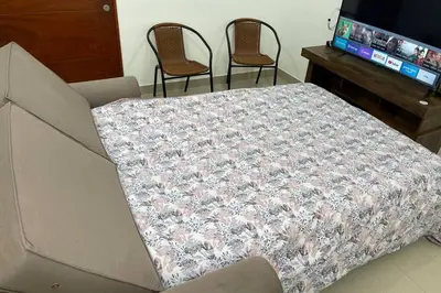 a bed in a room with two chairs and a television at 7-Departamento moderno en el área turística de Miraflores in Lima