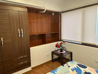 a bedroom with a bed and a table with flowers on it at 2- Amplio Departamento remodelado en Miraflores in Lima