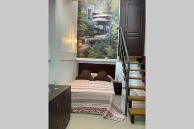 a bedroom with a bed with a window and a staircase at 4B Mini-departamento nuevo en centro de Miraflores in Lima