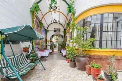a patio with plants and tables and an umbrella at Hotel Campanario in Cusco