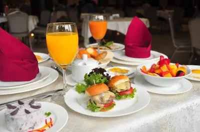 a table with plates of food and glasses of orange juice at Kingdom Hotel in Lima