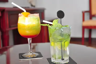 two cocktails are sitting on a table at Kingdom Hotel in Lima