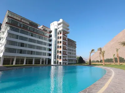 a hotel with a swimming pool in front of a building at Guizado Portillo Hacienda & Resort in Lunahuaná