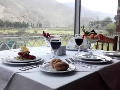 a table with plates of food and glasses of wine at Guizado Portillo Hacienda & Resort in Lunahuaná