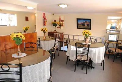 a dining room with tables and chairs with flowers on them at Hostal Alfredo's Palace in Cusco