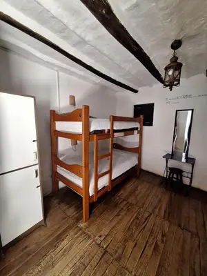 a bedroom with two bunk beds and a refrigerator at Intro Hostels Cusco in Cusco