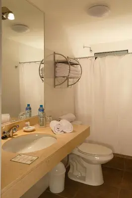 a bathroom with a sink and a toilet and a mirror at Casa Suyay in Lima
