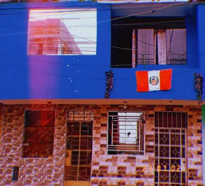a blue building with a flag on it at Inti Hostel Airport in Lima