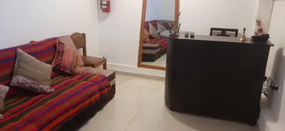 a living room with a couch and a mirror at Quipu Hostal in Machu Picchu