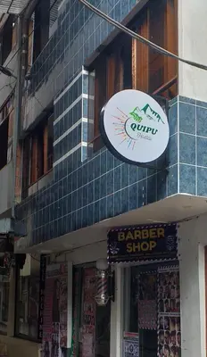 a butcher shop with two signs on the side of a building at Quipu Hostal in Machu Picchu