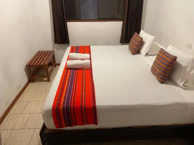 a bedroom with a large bed with towels on it at Quipu Hostal in Machu Picchu