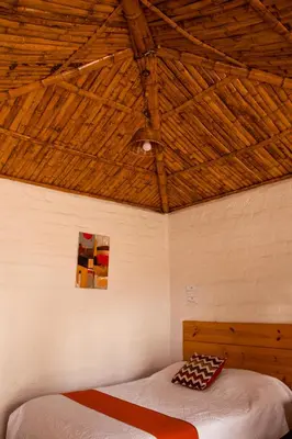 a bed in a room with a wooden ceiling at La Estancia Chincha Hotel in Chincha Alta