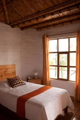 a bedroom with a bed and a large window at La Estancia Chincha Hotel in Chincha Alta