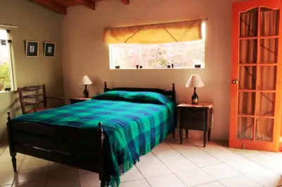 a bedroom with a green bed and a window at Huaranjapo in El Carmen