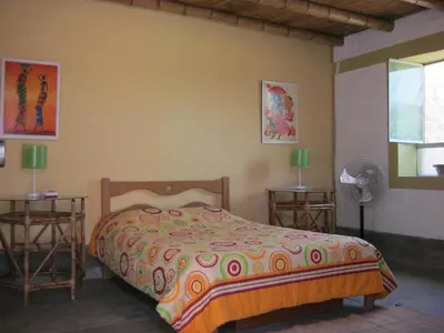 a bedroom with a bed and two tables with lamps at Huaranjapo in El Carmen
