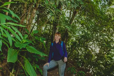 a woman is standing in front of a tree at Rupa Rupa High Jungle Eco B&B in Machu Picchu
