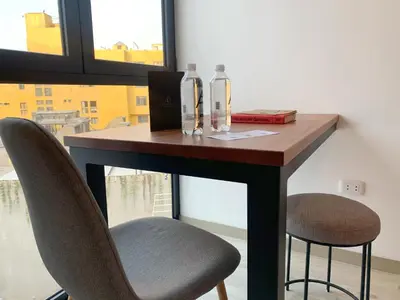 a table with two chairs and two bottles on it at Primera Parada By Wynwood House in Lima