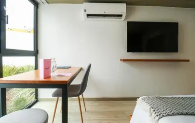 a room with a desk and a tv on the wall at Primera Parada By Wynwood House in Lima