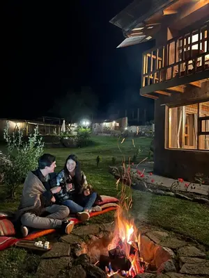 a man and woman sitting next to a fire at Unuwasi Hotel & Villa in Calca