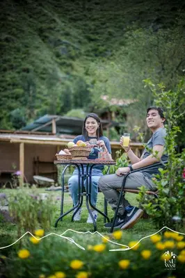 a man and woman sitting at a table with a drink at Unuwasi Hotel & Villa in Calca
