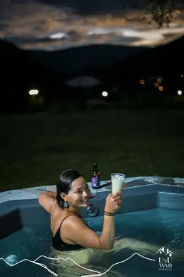 a woman holding a drink in a swimming pool at Unuwasi Hotel & Villa in Calca