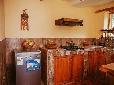 a kitchen with a stove and a refrigerator at Unuwasi Hotel & Villa in Calca