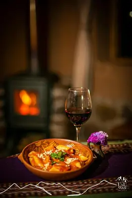 a bowl of pasta and a glass of wine at Unuwasi Hotel & Villa in Calca