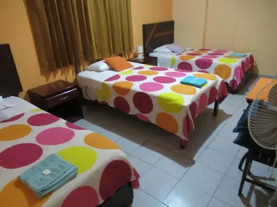 a room with three beds with polka dots at Kurmi Hostel Lima Airport in Lima