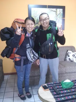 a man and a woman giving the peace sign at Kurmi Hostel Lima Airport in Lima
