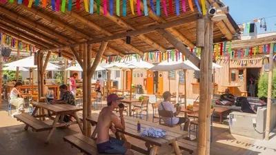 a group of people sitting at tables in a restaurant at Viajero Paracas Hostel in Paracas