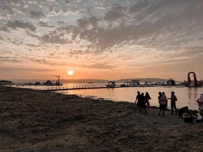 a group of people walking on the beach at sunset at Viajero Paracas Hostel in Paracas