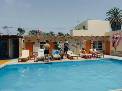 a group of people standing around a swimming pool at Viajero Paracas Hostel in Paracas