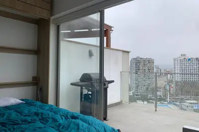 a bedroom with a bed and a large glass window at Barranco Penthouse ocean boardwalk in Lima