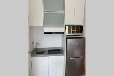 a kitchen with white cabinets and a stainless steel refrigerator at Barranco Penthouse ocean boardwalk in Lima