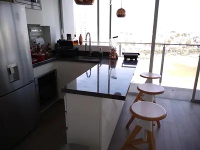 a kitchen with two bar stools and a counter top at Barranc Group Penthouse in Lima
