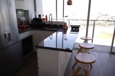 a kitchen with two bar stools and a counter top at Barranc Group Penthouse in Lima