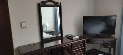 a television sitting on a dresser in front of a mirror at San Borja Habitación amoblada independiente dentro de departamento amoblado tipo ROOMMIE Tv42 Cerca JockeyPlaza in Lima